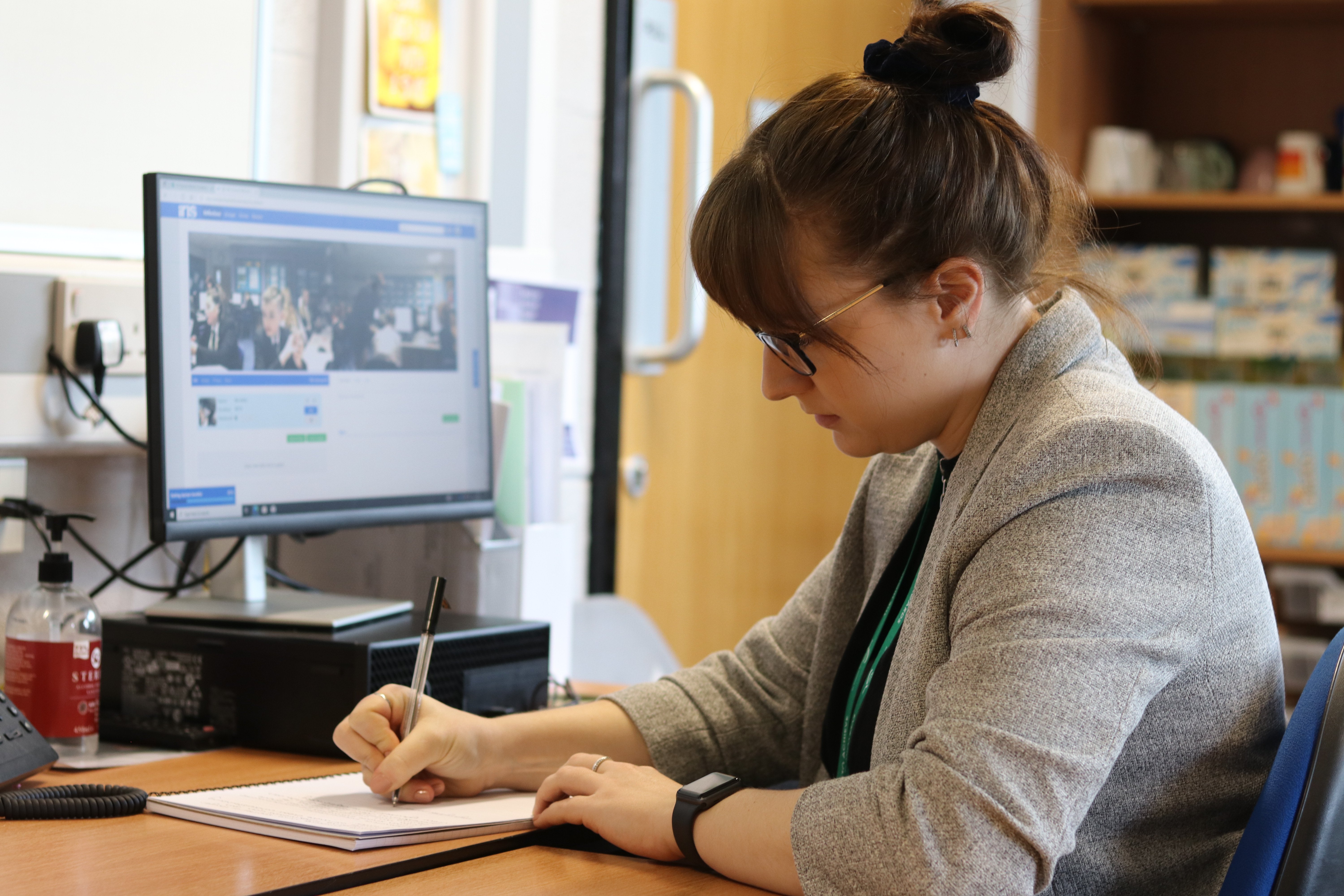 A female teacher using a computer reflecting on her teaching practice with IRIS Connect