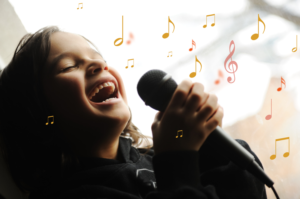 Musician kid singing a song with microphone