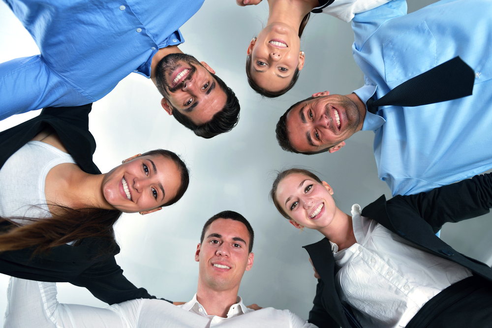 business people group joining hands and representing concept of friendship and teamwork, low angle view