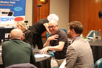 Group talking, one man in the centre smilling