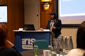 Tejinder Deeks presenting in front of a podium